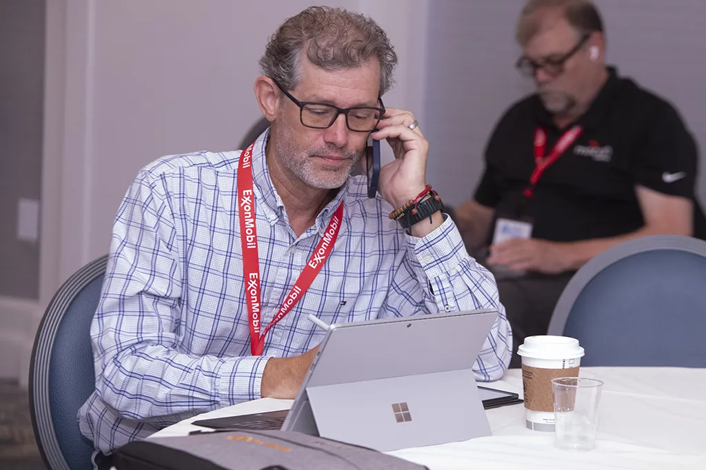 A man using wifi on his phone and laptop at RemTEC & Emerging Contaminants Summit